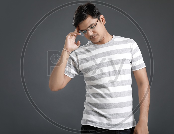 Thinking  Young Man Holding Head With Hands And Posing Over an Isolated Black Background