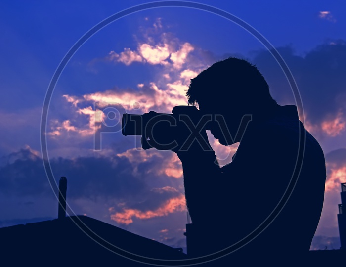 Silhouette Of a Photographer Over Blue Hour Sky In Background