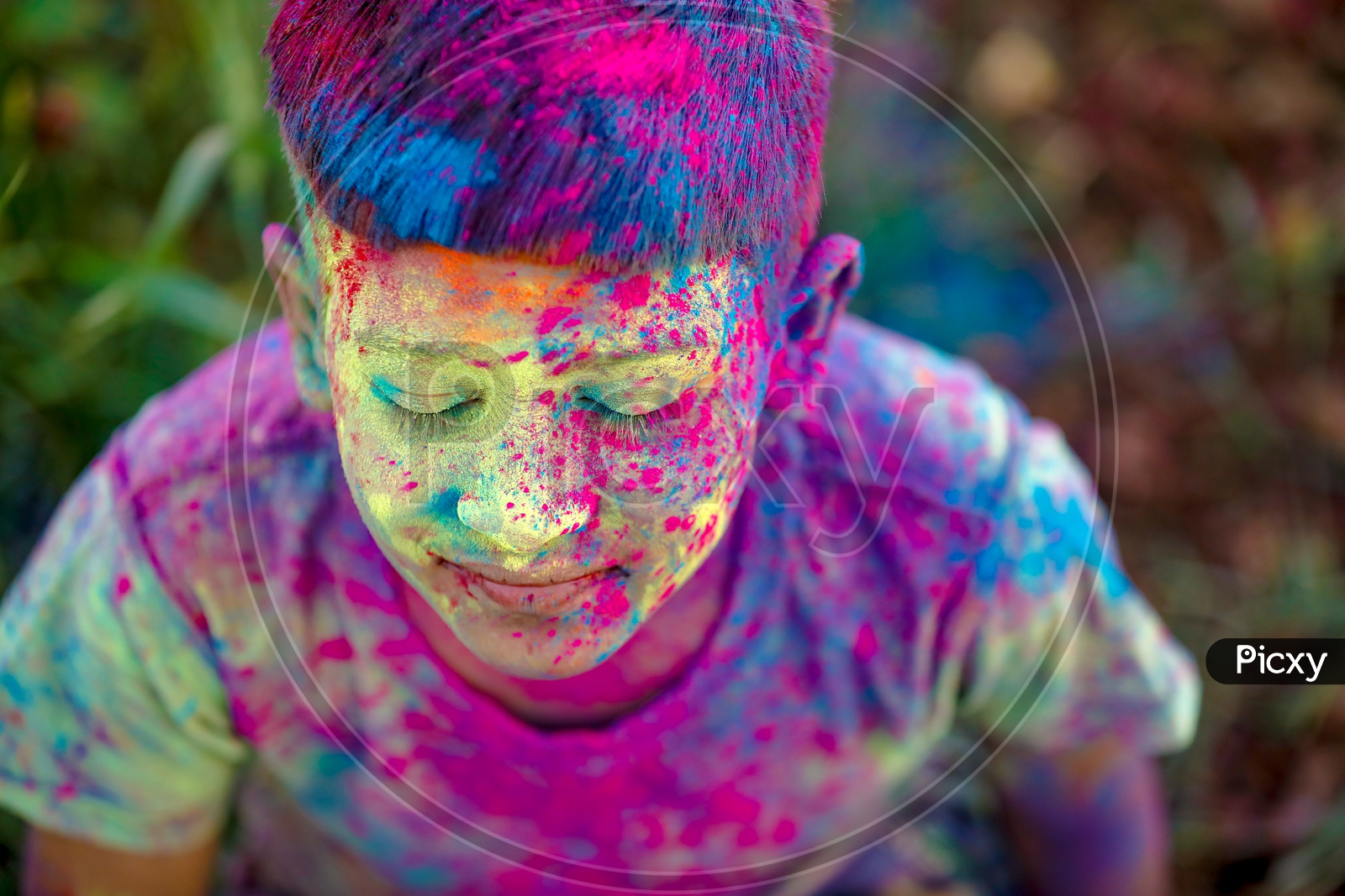 Indian Boy or Young Indian Boy  Playing Or Filled In Holi Colours Celebrating Holi Festival in Green Fields Background