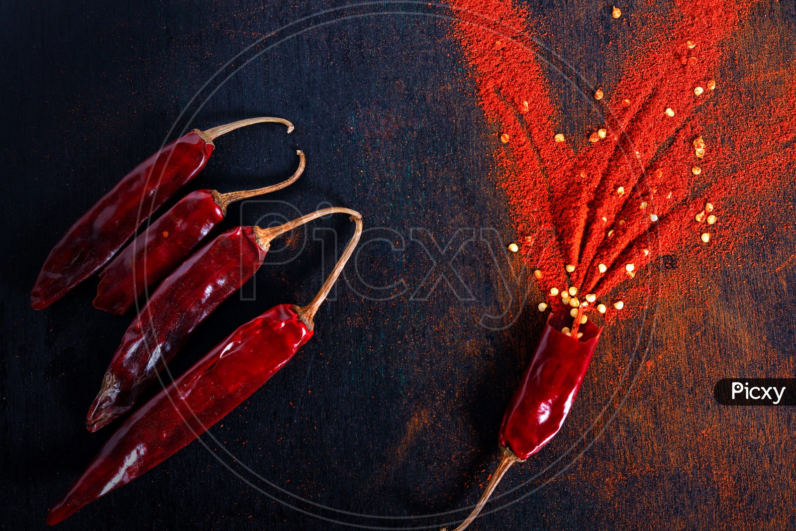 Red Chilli  Or Pepper Powder  With Chilli  Flakes On an Isolated Black Background