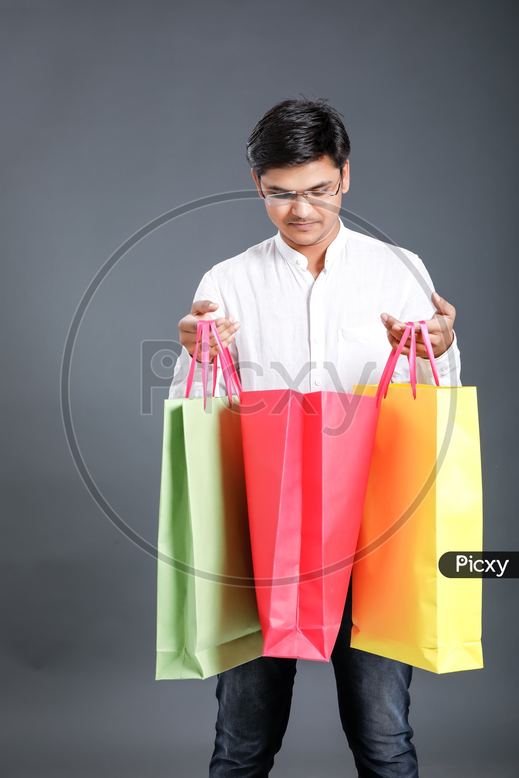Young Man Carrying  Shopping Bags  And Posing Over an Isolated Black Background