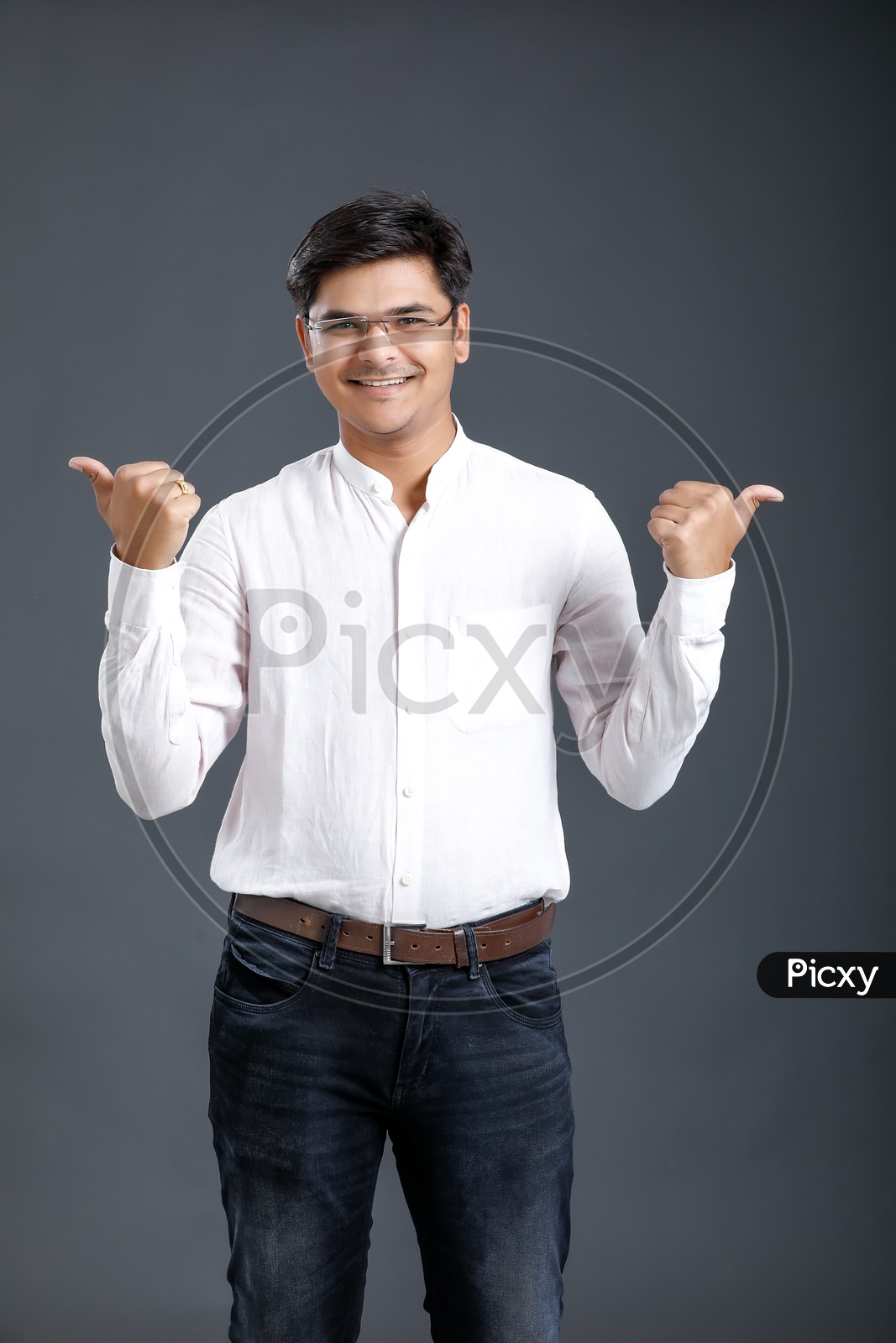 Young man Or Indian man Happily Smiling And Showing Space   Over an Isolated  Black Background