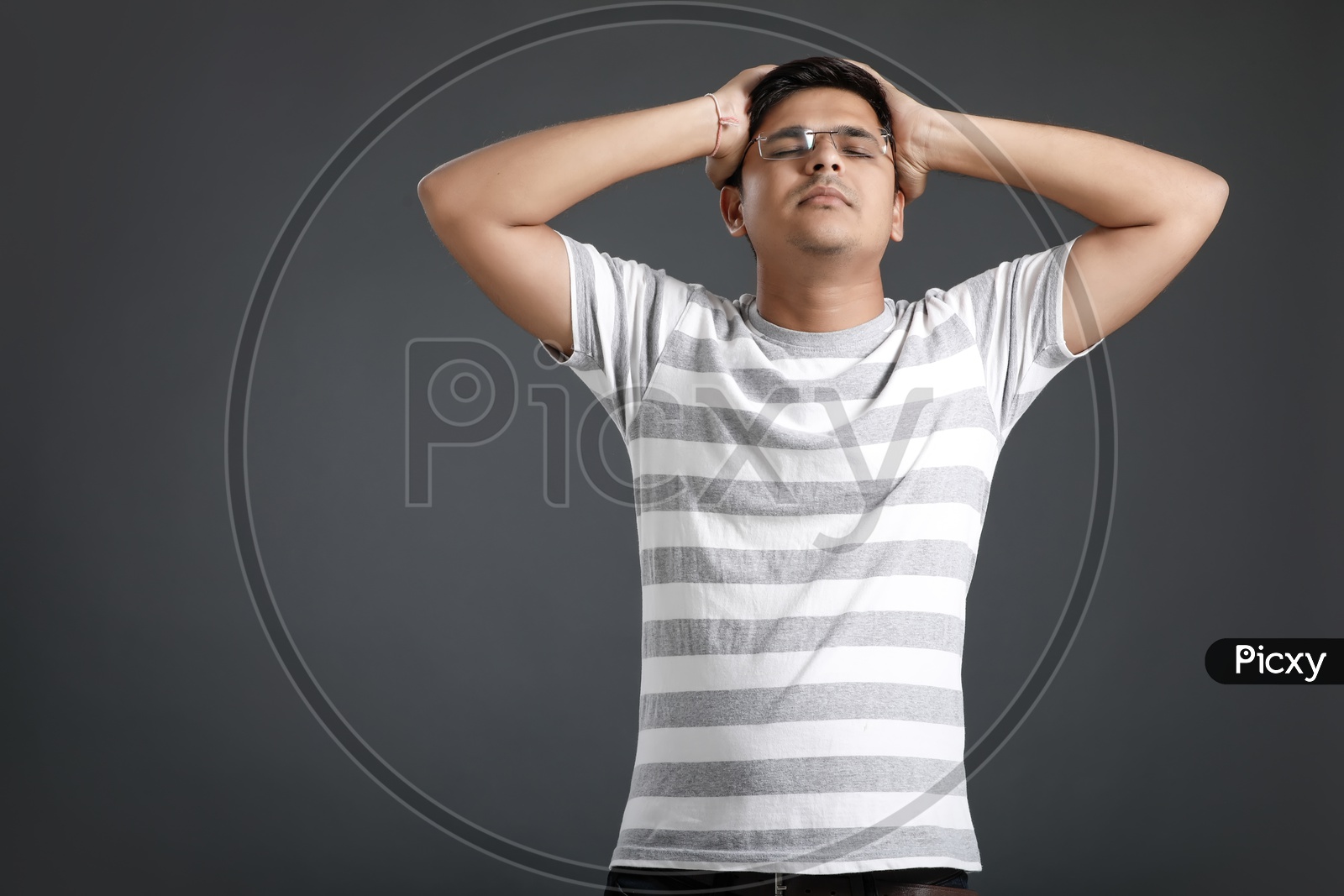Frustrated Stressed Young Man Holding Head With Hands And Posing Over an Isolated Black Background