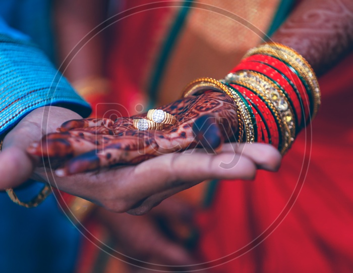 Couple Holding Engagement Rings on Hand  Wearing Traditional Wear on an Marriage Engagement Ceremony