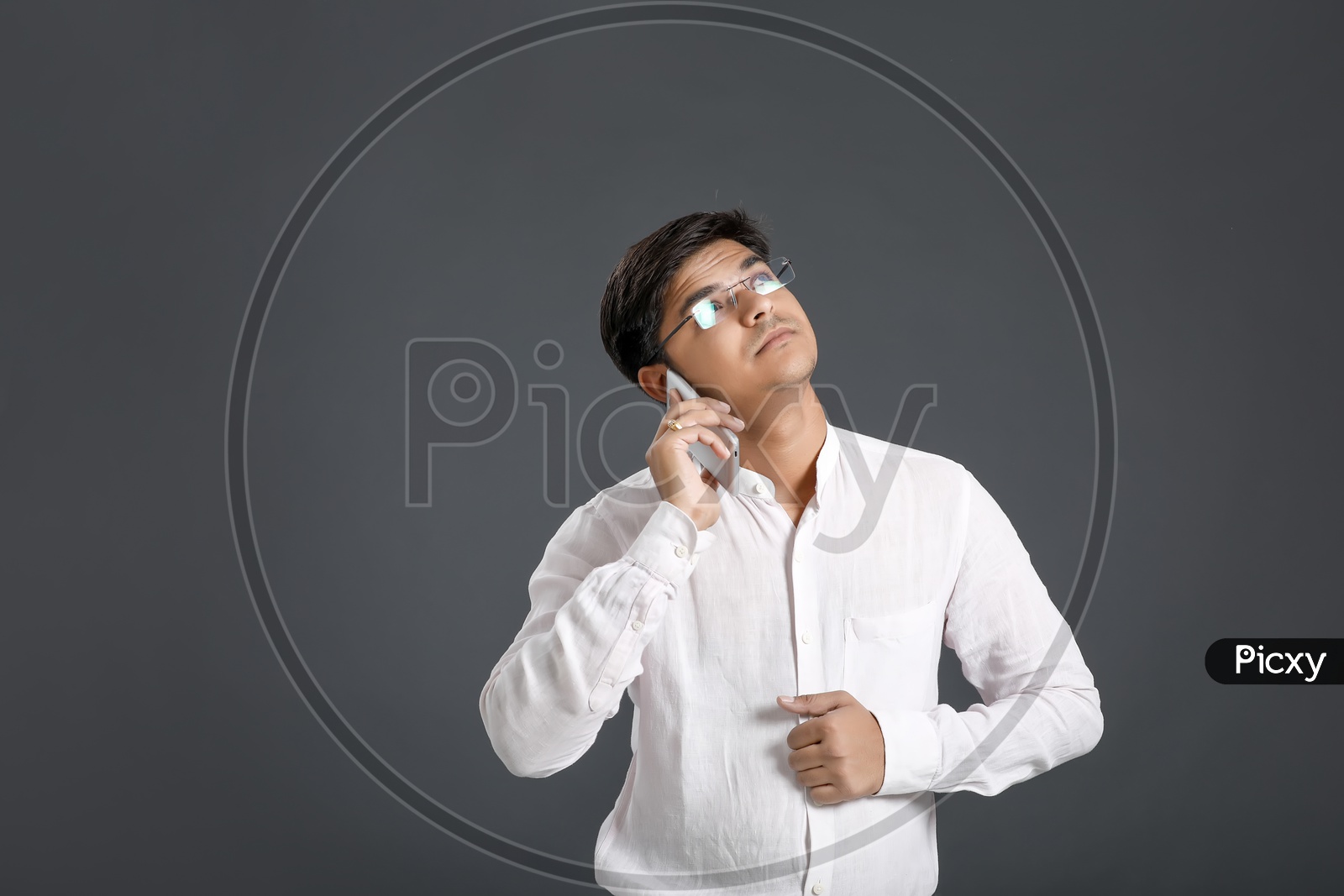 Young Man or Indian  Man Speaking In Smart Phone Or Mobile Over An Isolated Black Background