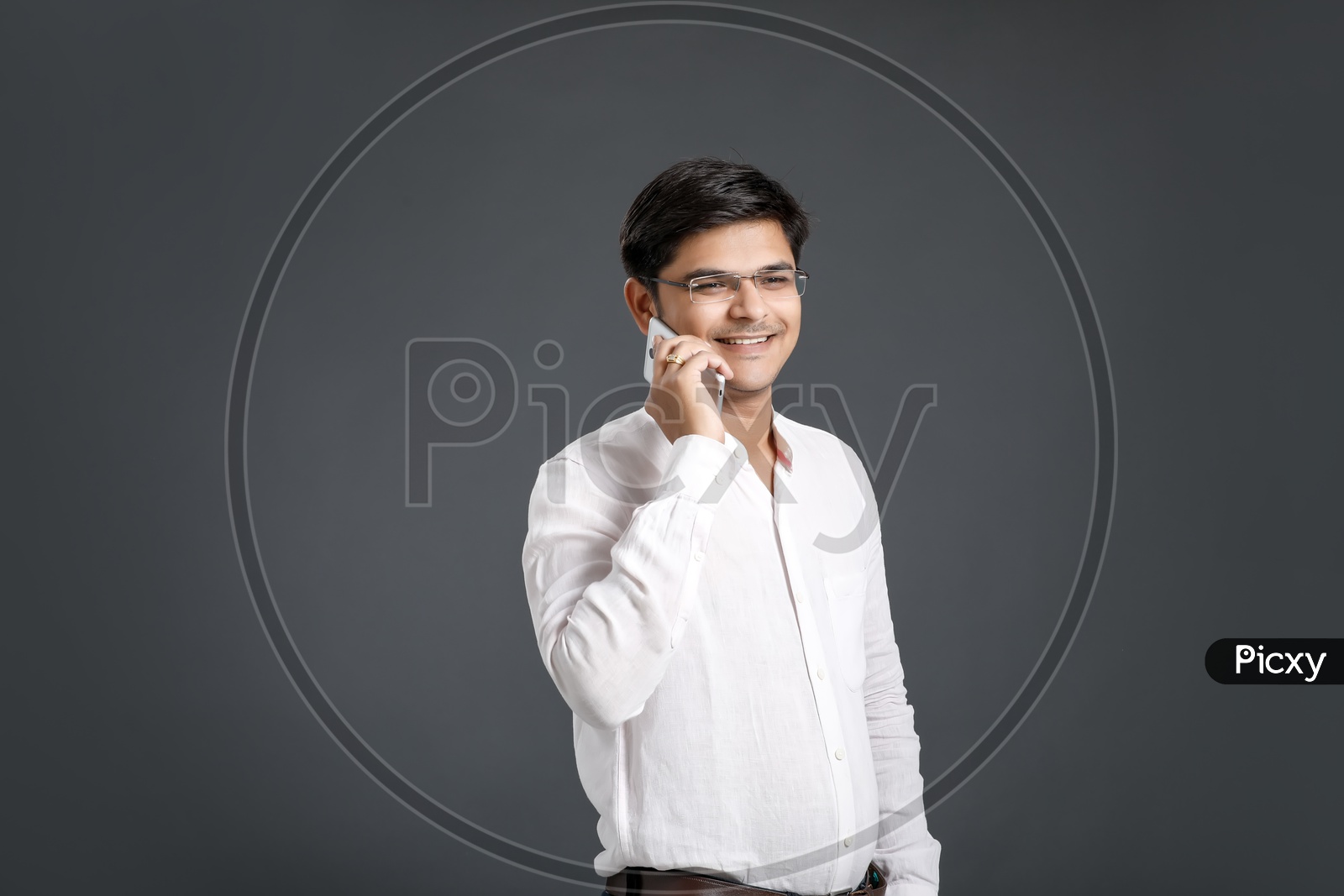 Young Man or Indian  Man Speaking In Smart Phone Or Mobile Over An Isolated Black Background