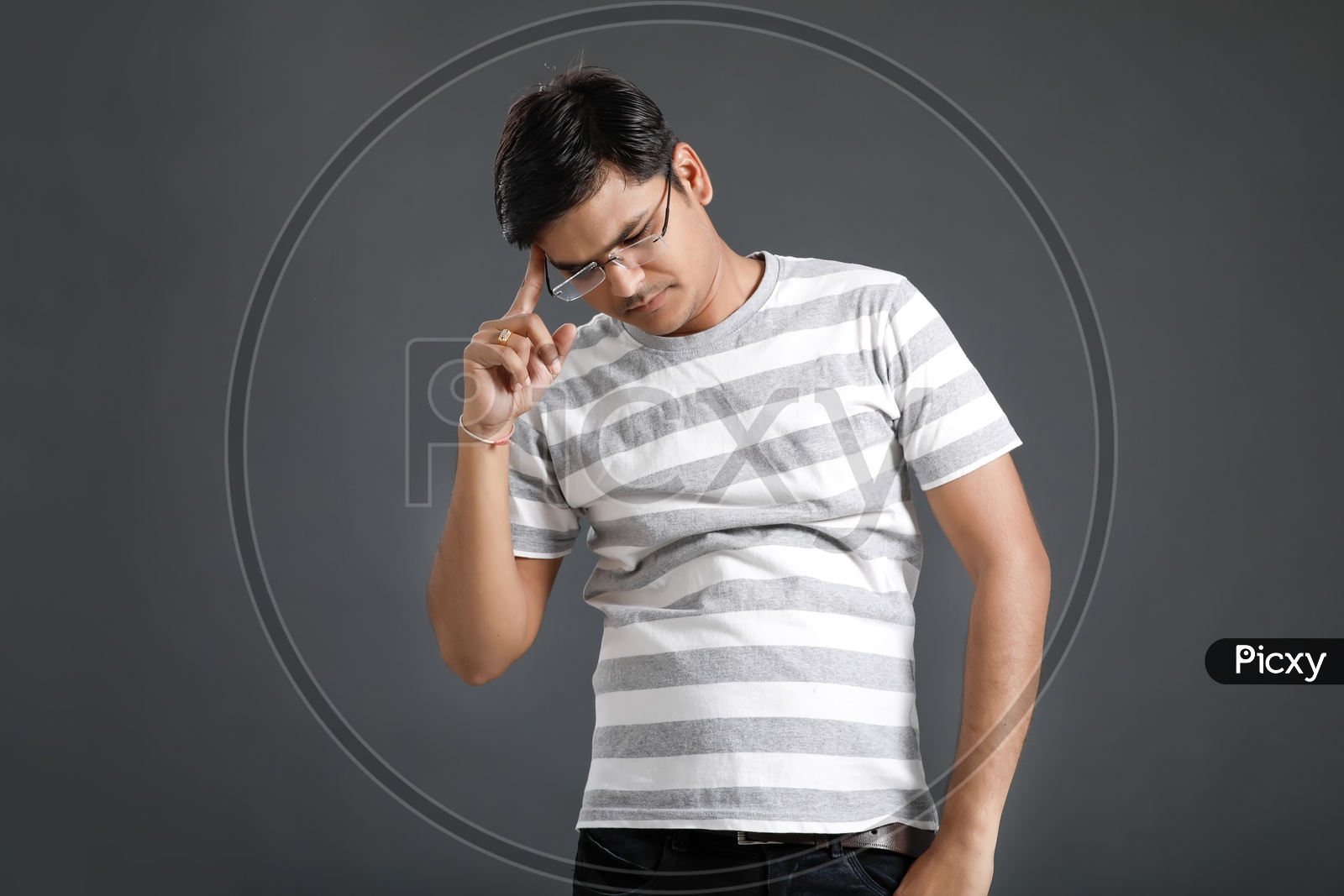 Thinking  Young Man Holding Head With Hands And Posing Over an Isolated Black Background