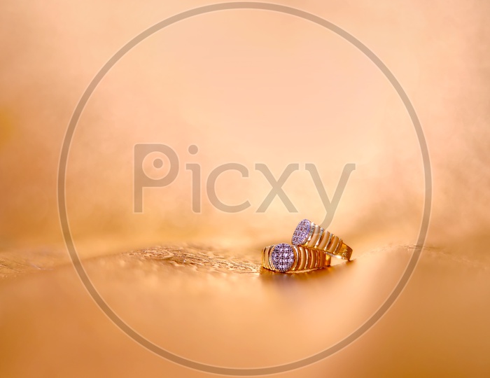Couple Engagement Rings  Isolated On Golden Light Background
