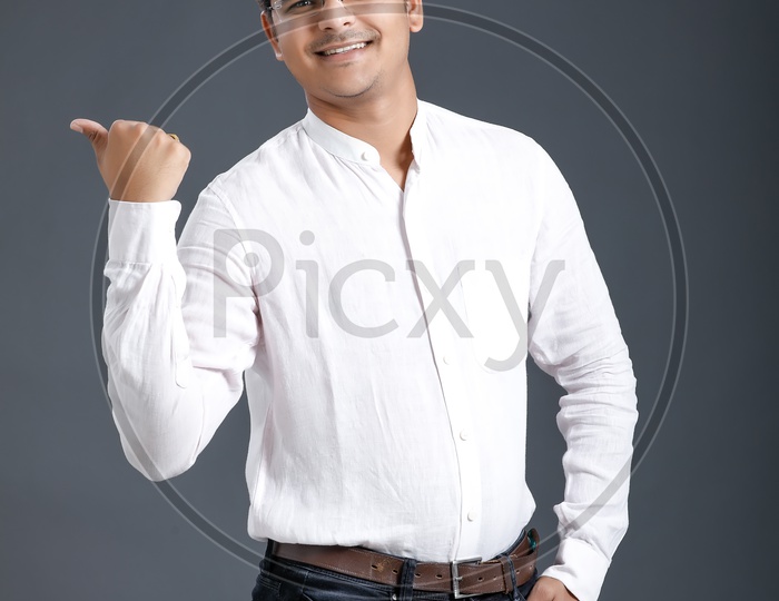 Young man Or Indian man Happily Smiling And Showing Space   Over an Isolated  Black Background