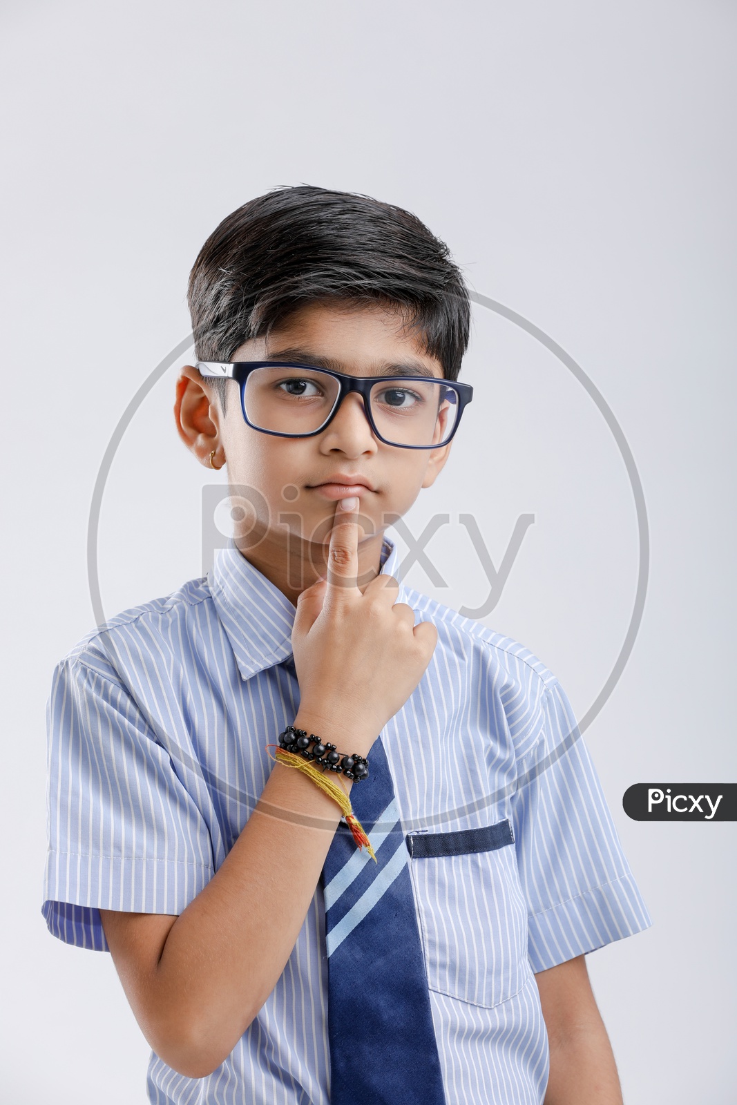 Indian Or Asian Boy Or Kid Or student in School Uniform  Wearing Spectacles And  Posing  Over an Isolated White Background