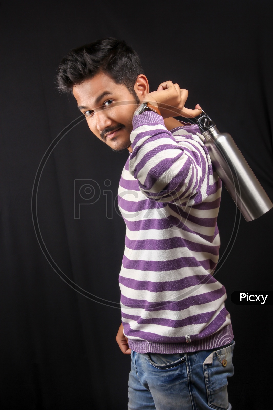 Young Indian Man Posing With Water Bottle  On an Isolated Black Background