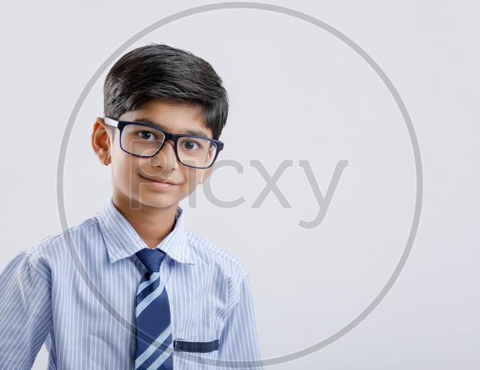 Cute Indian or Asian Kid Or Boy In School Uniform And Wearing Spectacles  Over an Isolated White Background