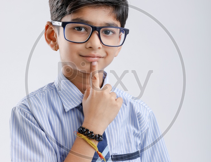 Indian Or Asian Boy Or Kid Or student in School Uniform  Wearing Spectacles And  Posing  Over an Isolated White Background
