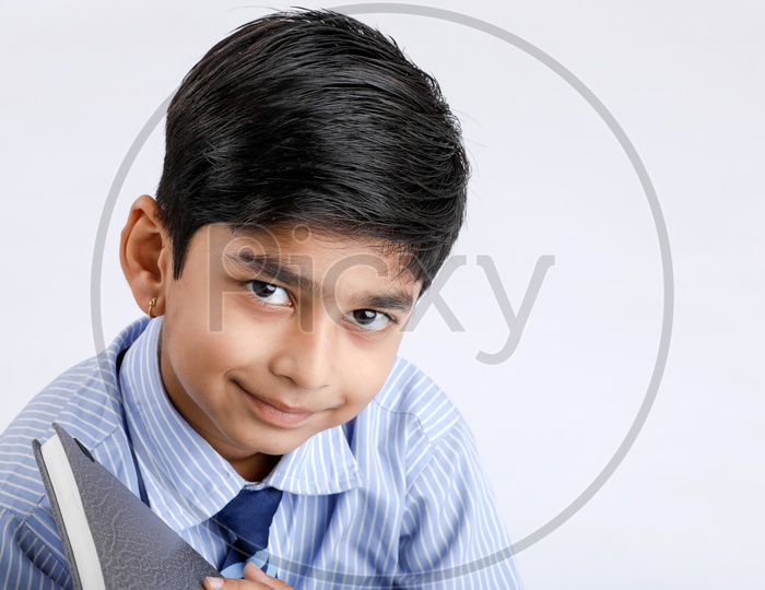 Indian or Asian School Kid Or Boy Wearing Uniform  And Posing Over an Isolated White Background