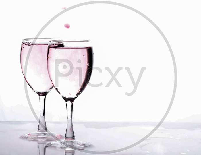 Red Food Colouring Diffuse In water in a Wine Glass On an Isolated White Background
