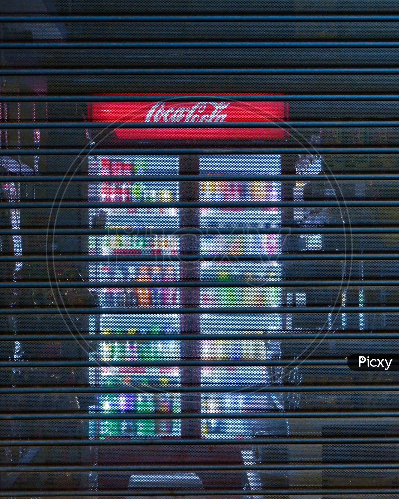 Vending machine with blue light in a closed shop at night. Coca cola