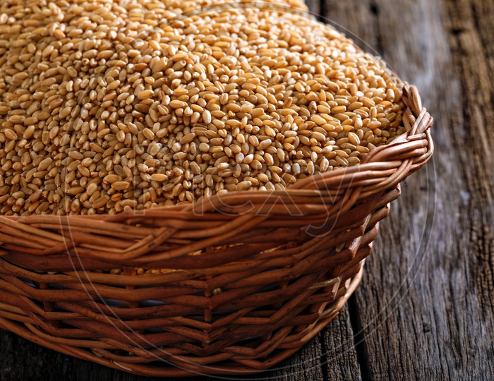 Wheat Grains In an Wooden Weaved Basket On an Isolated Wooden Background