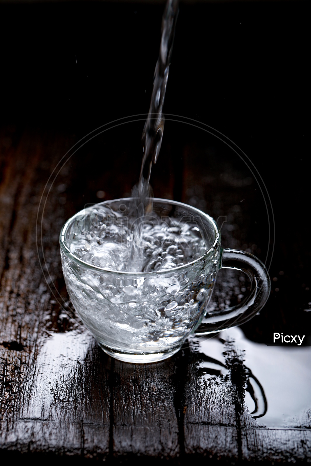 Empty Glass  Tea Cup Filling With Water On an Wooden  Table Background