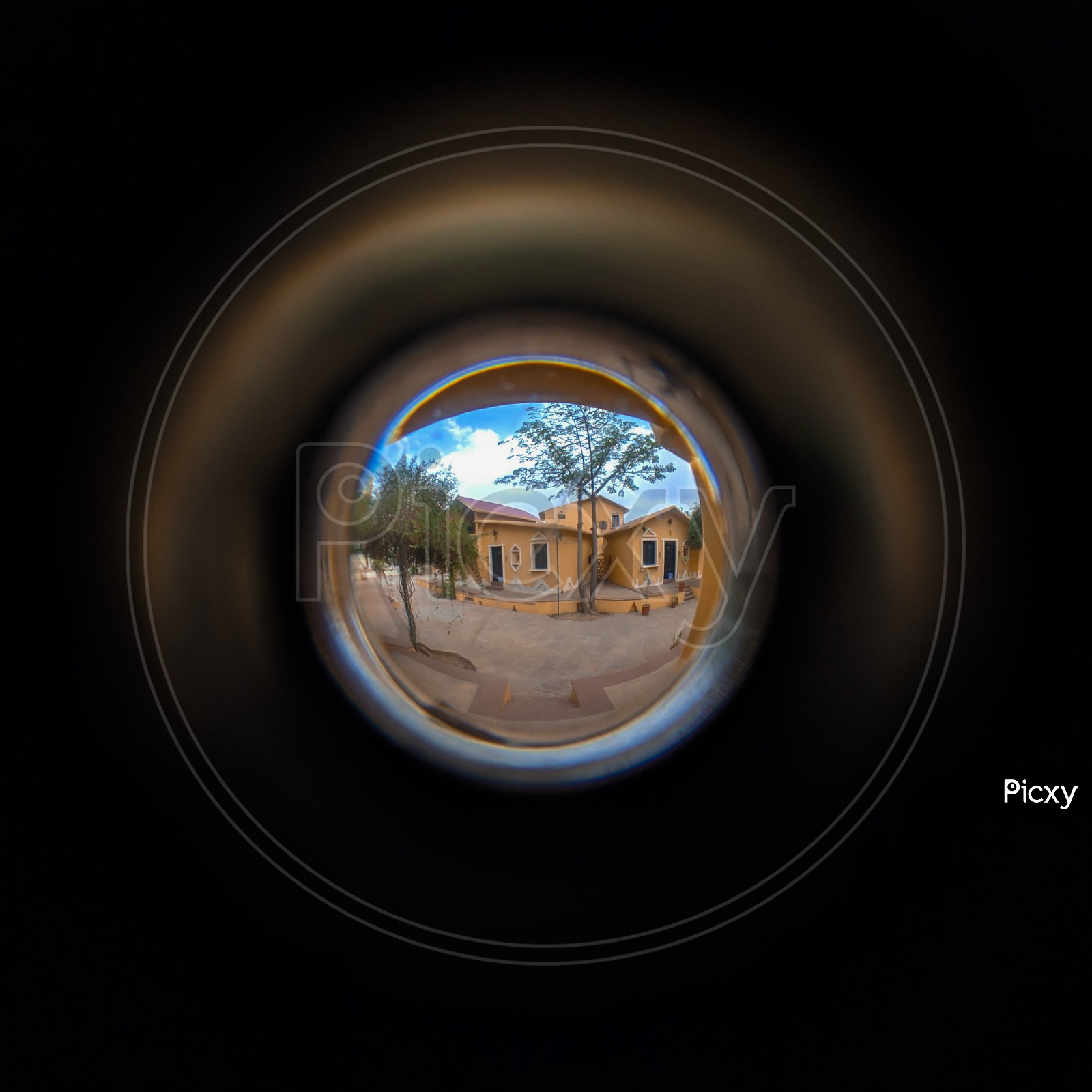 A view of cottages through a peephole , in a resort .