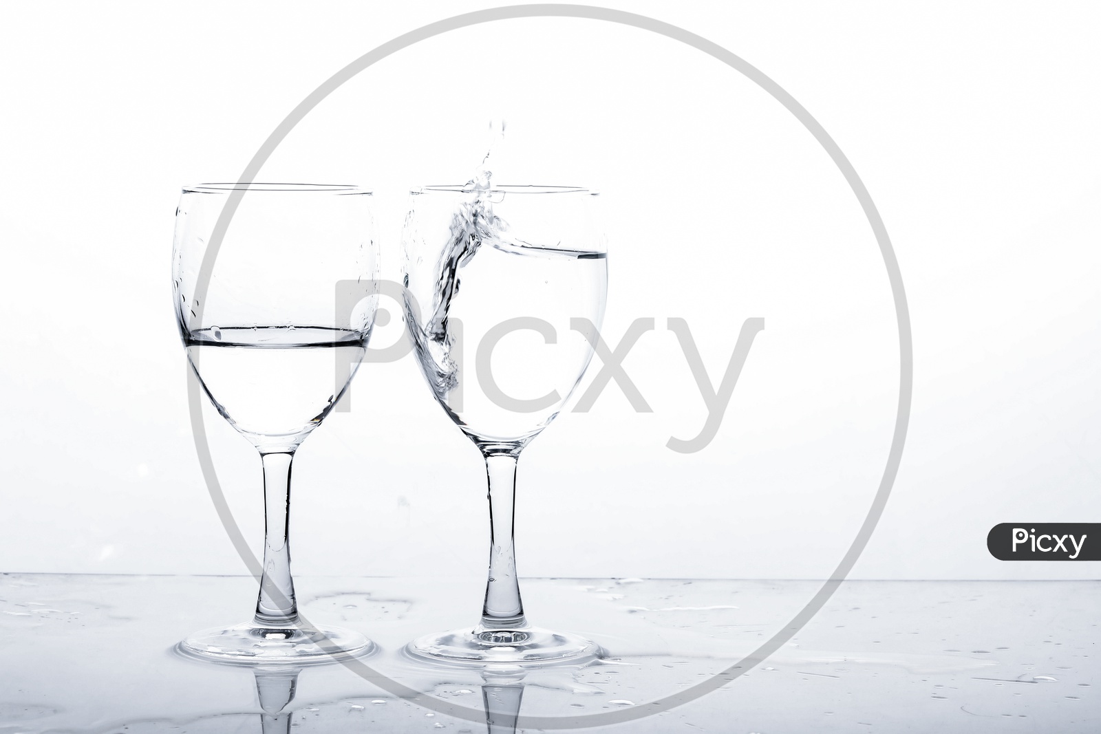 Empty Wine Glasses Filled With Water And Water Splash  On an Isolated White Background