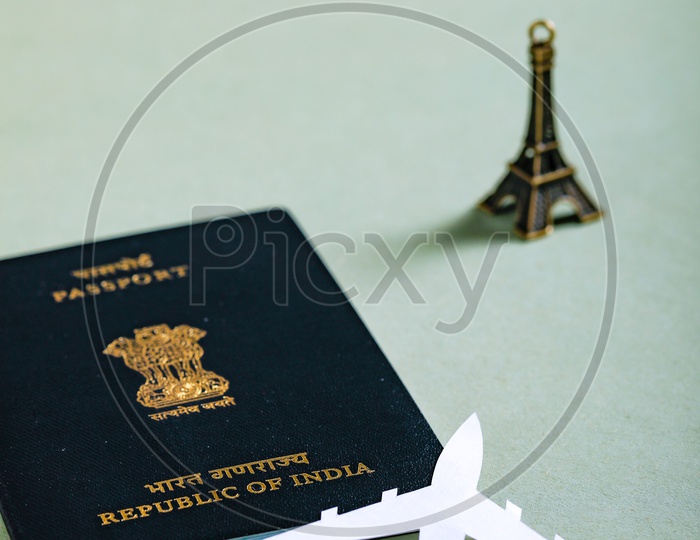 Travel Concept  Indian Passport And Paper Airplane Eiffel Tower Miniature on an Isolated White Background