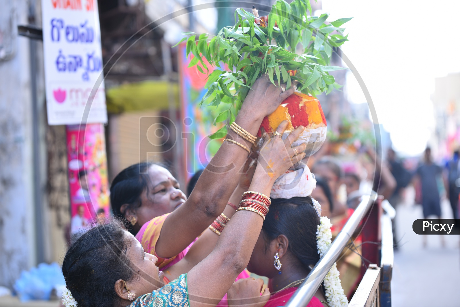 A Woman  Carrying Bonam or Bonalu On Her Head  in Queue Lines For Goddess Ujjaini Mahakali Temple During Bonalu Festival