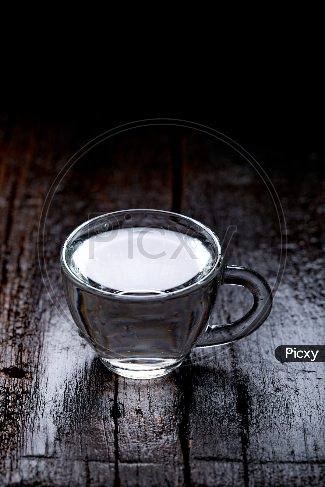 Empty Glass  Tea Cup Filling  With Water On an Wooden  Table Background