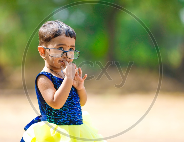 Cute Indian Girl Child Or Baby Child Wearing Spectacles In Outdoor Background