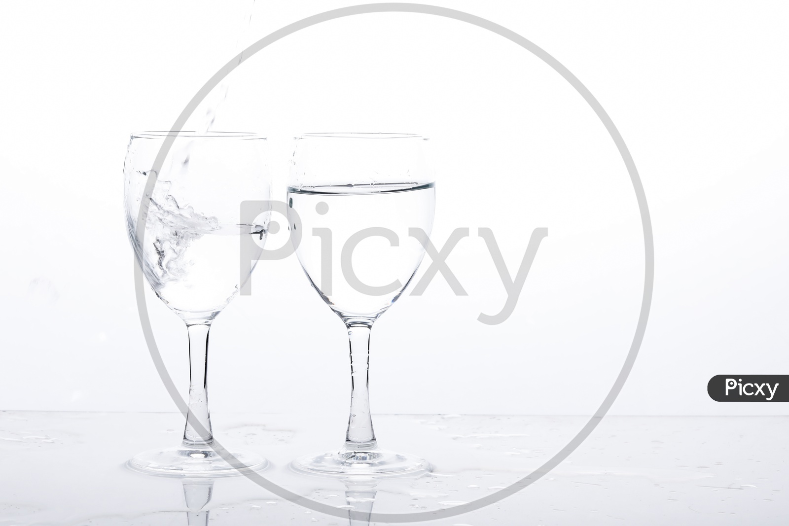 Empty Wine Glasses Filled With Water And Water Splash  On an Isolated White Background