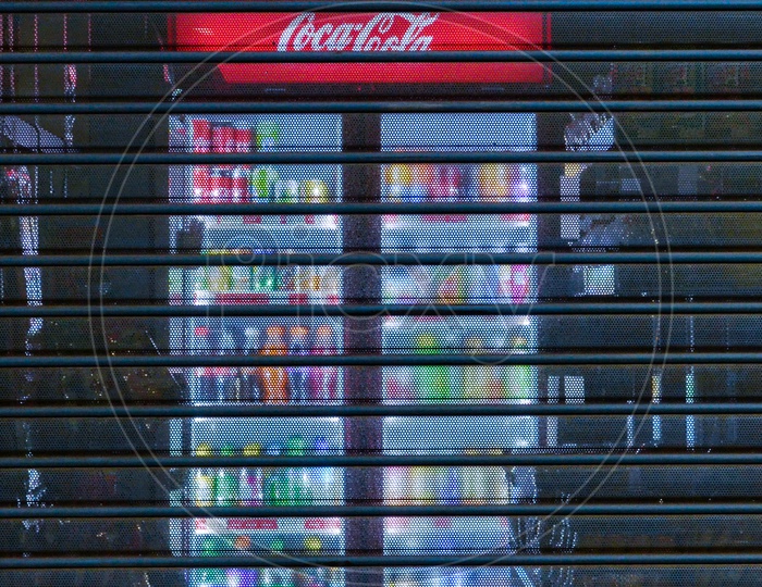 Vending machine with blue light in a closed shop at night. Coca cola