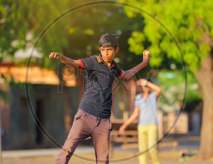 Indian Rural Village Kids Playing Cricket In Fields