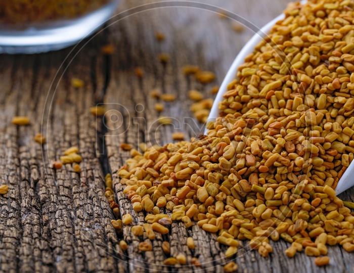 Fenugreek Seeds In a Scoop on an Isolated Wooden Background