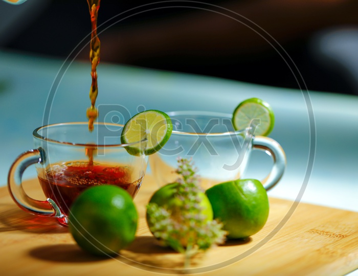 Black Tea in Glass Cup With Lemons And Holi basil  On an Wooden Table Background