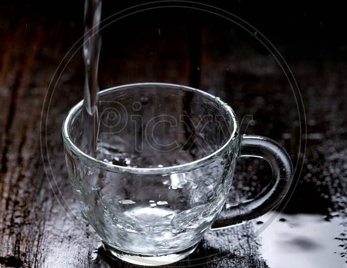Empty Glass  Tea Cup Filling With Water On an Wooden  Table Background
