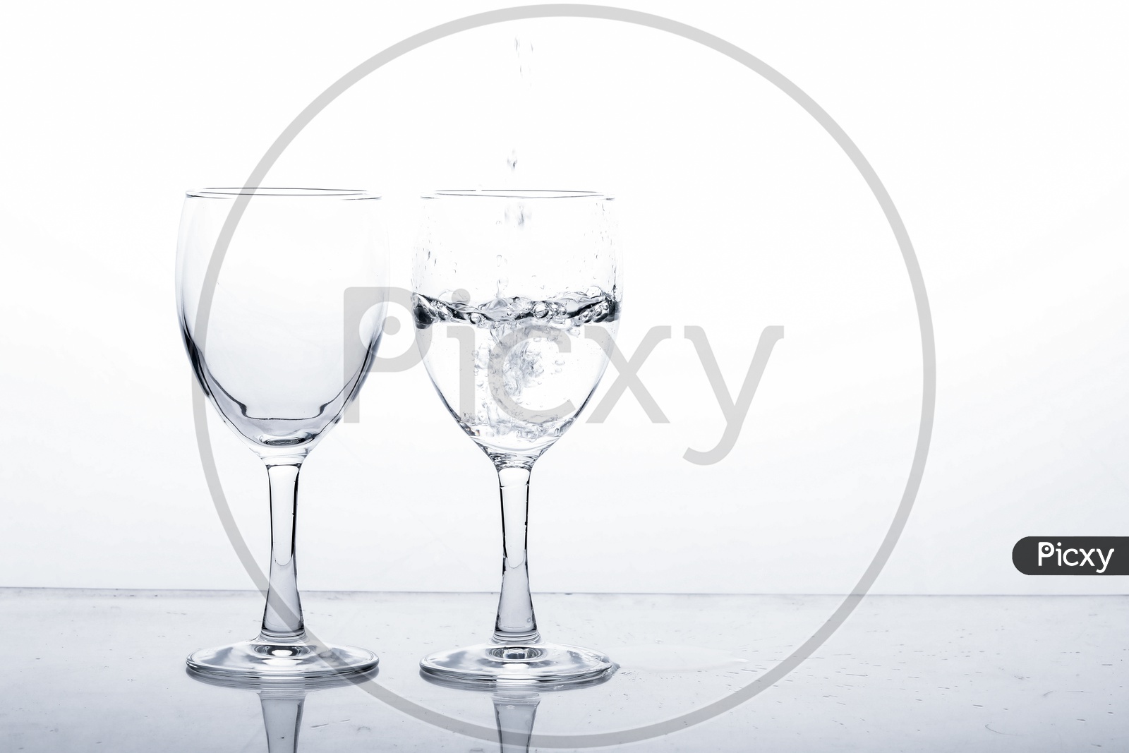 Empty Wine Glasses Filled With Water and Water Splash  On an Isolated White Background