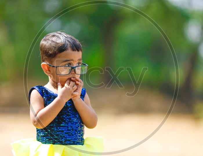 Cute Indian Girl Child Or Baby Child Wearing Spectacles In Outdoor Background