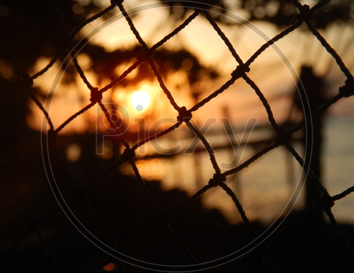 Sunrise through a net at fisherman's bay in kerala.
