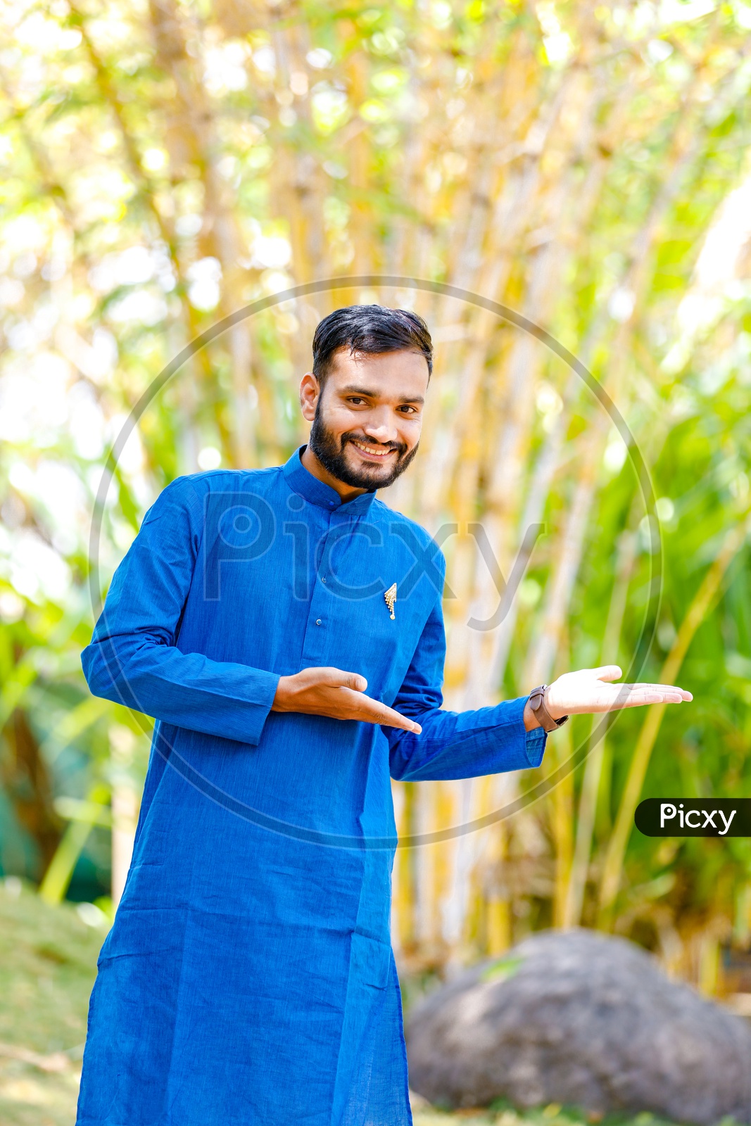Image of Indian Man Wearing Traditional Wear and Showing  Space-UH778378-Picxy