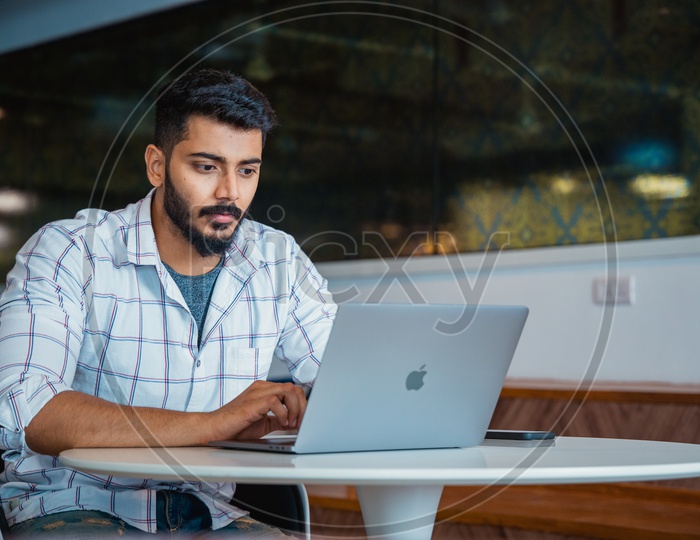 Focused Serious Working Young Man Or Indian Man On Laptop In Office Work Space