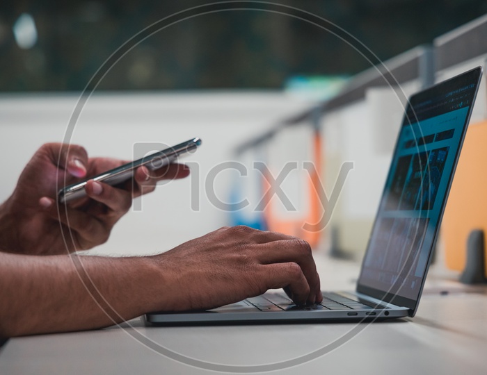 Young Man Or Student Hands Using Mobile Or Smartphone On Laptop Keyboard  On Office  Desk Background
