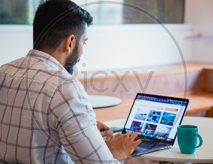 Young Man Or Indian Man Working On Laptop With Coffee Cup on Office desk
