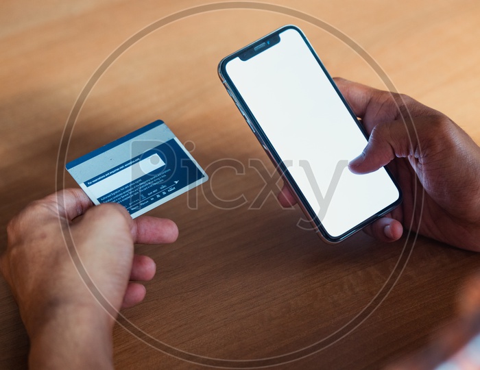 Online Payments Or Online Shopping  A Young Man Using Debit or Credit Card For Online Transaction or Payments in Smartphone or Mobile