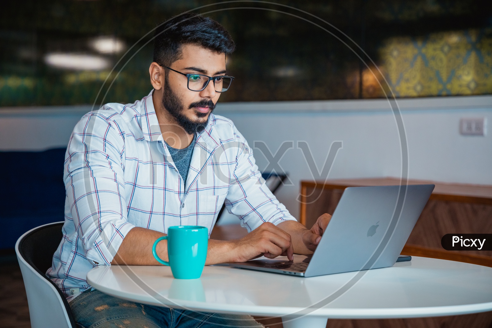 Focused Serious Working Indian Professional Young Man IT Employee  On Laptop In Office Work Space
