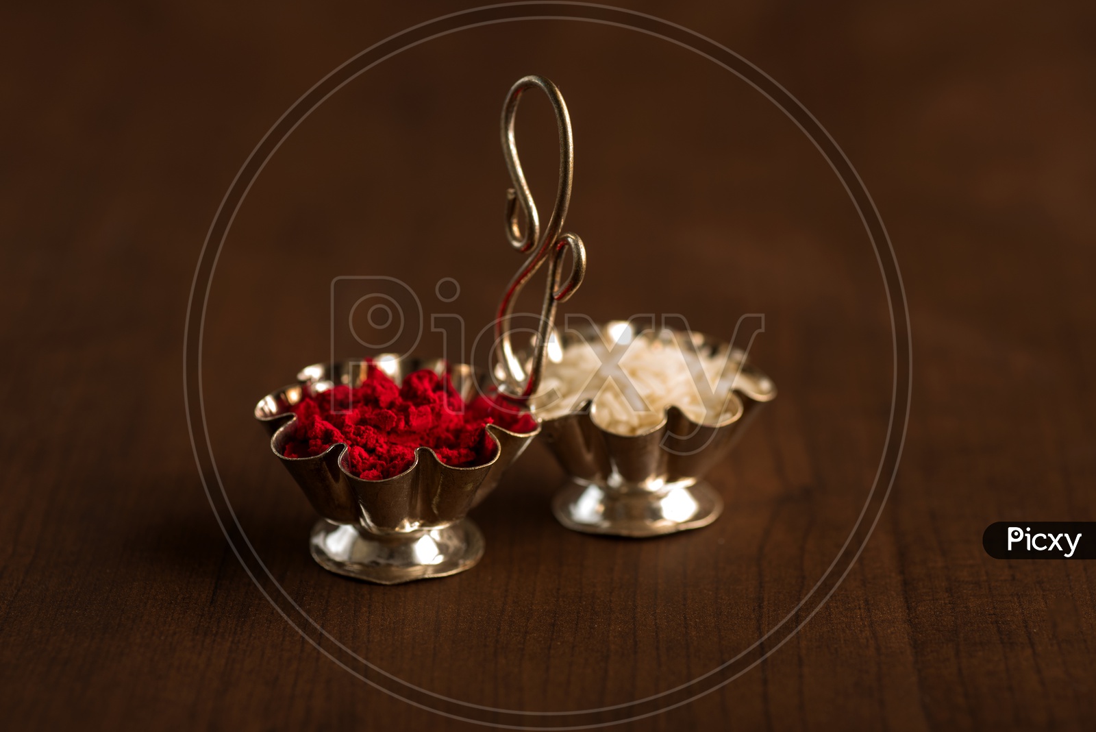 Kumkum And Rice Grains For Hindu Worship  In a  Container on an Wooden Background