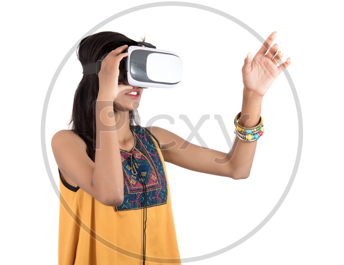Beautiful Girl Looking Through  VR  Device  or   Young Girl Wearing  Virtual Reality  Goggle Headset  on an Isolated White Background