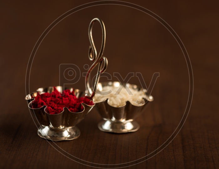 Kumkum And Rice Grains For Hindu Worship  In a  Container on an Wooden Background