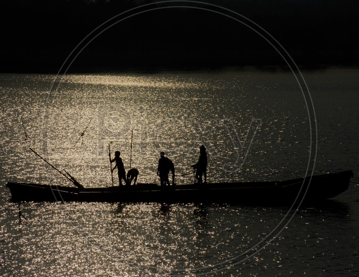 Silhouette Of Fisherman In Boat  On  a lake
