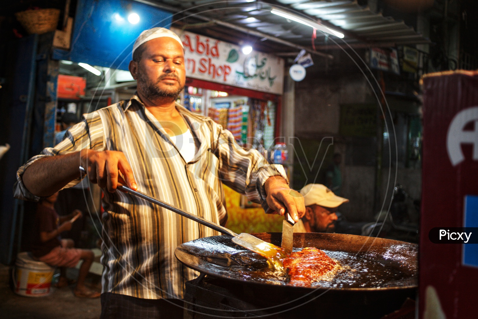 A Street Food Vendor Making Fish Fry At a Stall