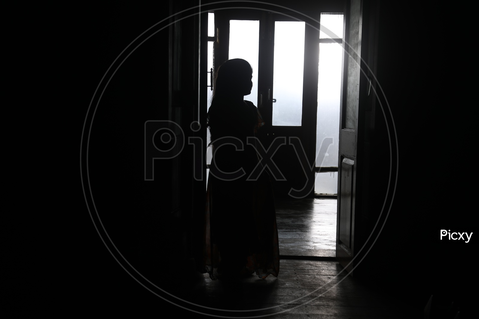 Silhouette of a Girl Child On a House Over Sunlight Through Windows