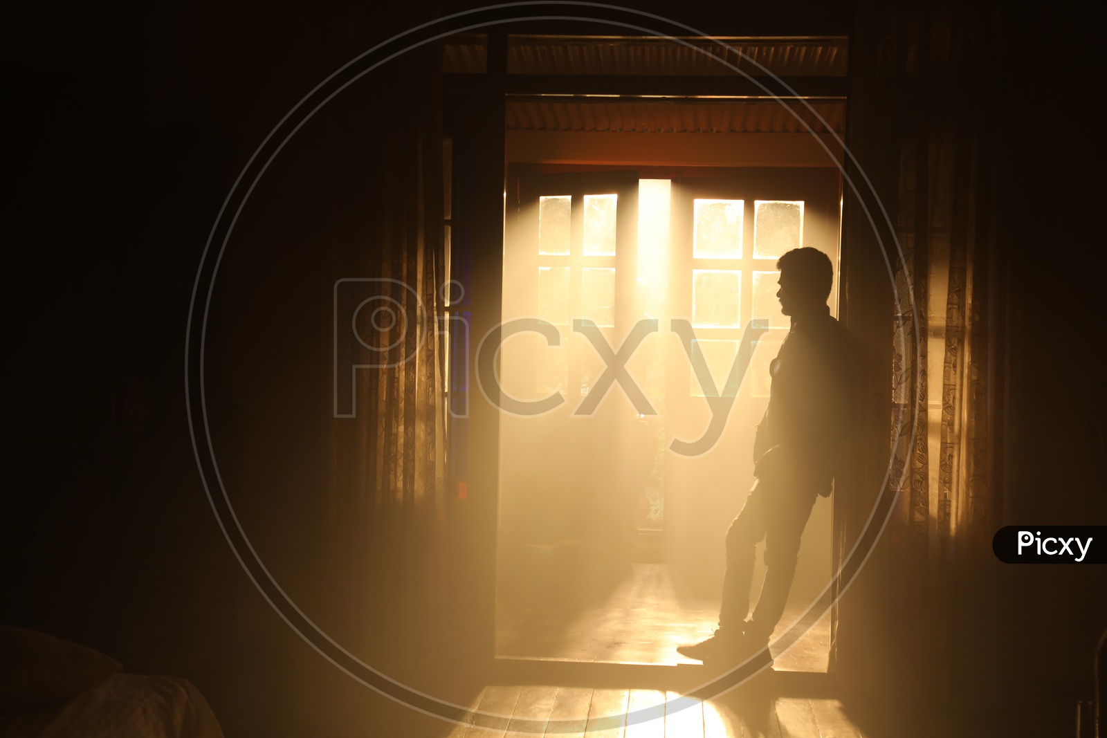 Silhouette Of a Man Over a Light Through a House Door